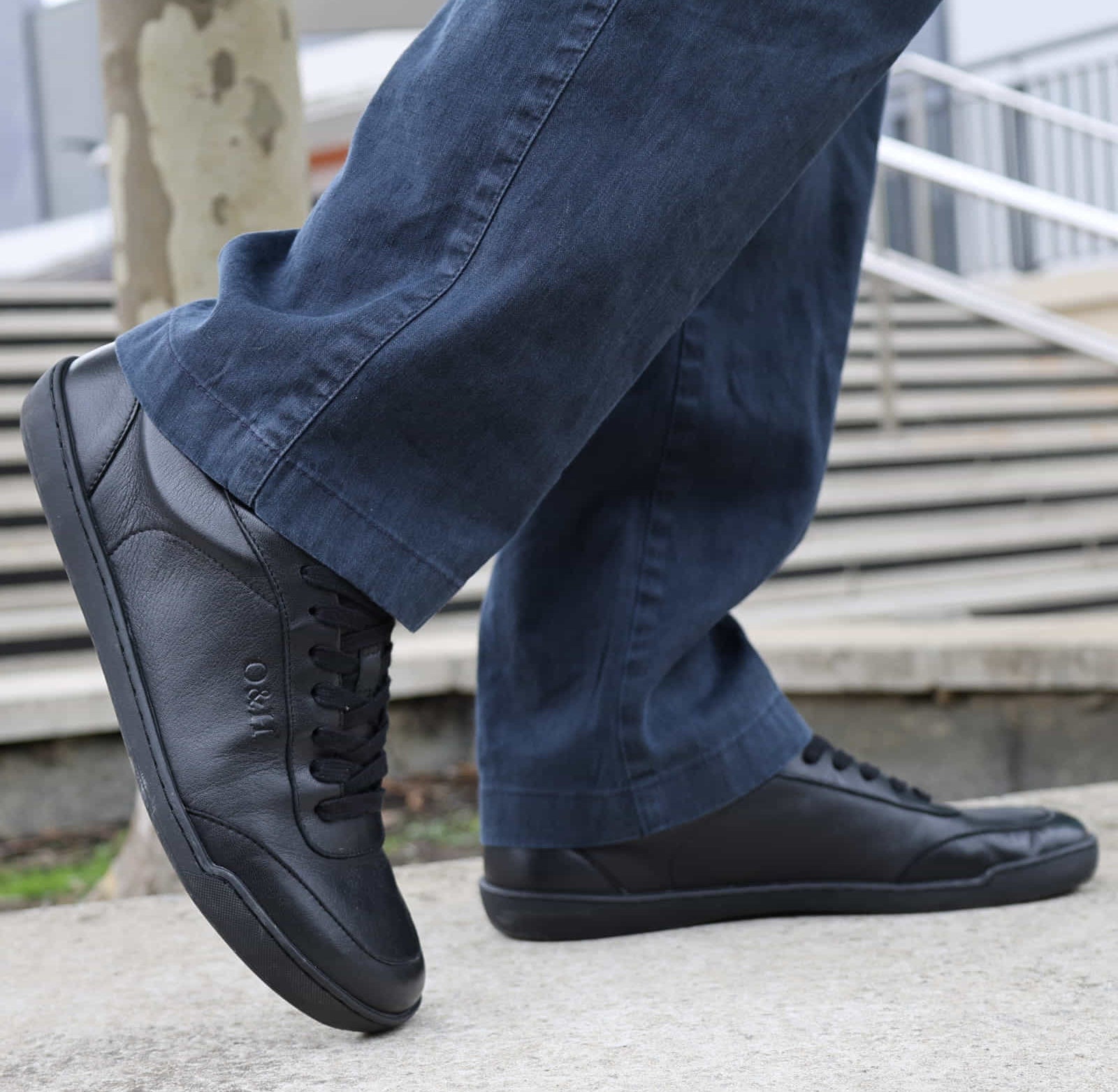 model standing in black barefoot trainers paired with casual dark jeans
