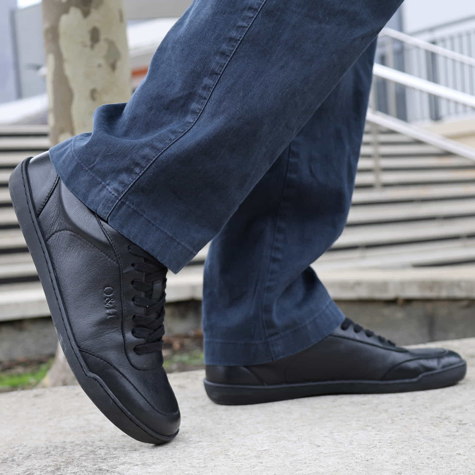 model standing in black barefoot trainers paired with casual dark jeans