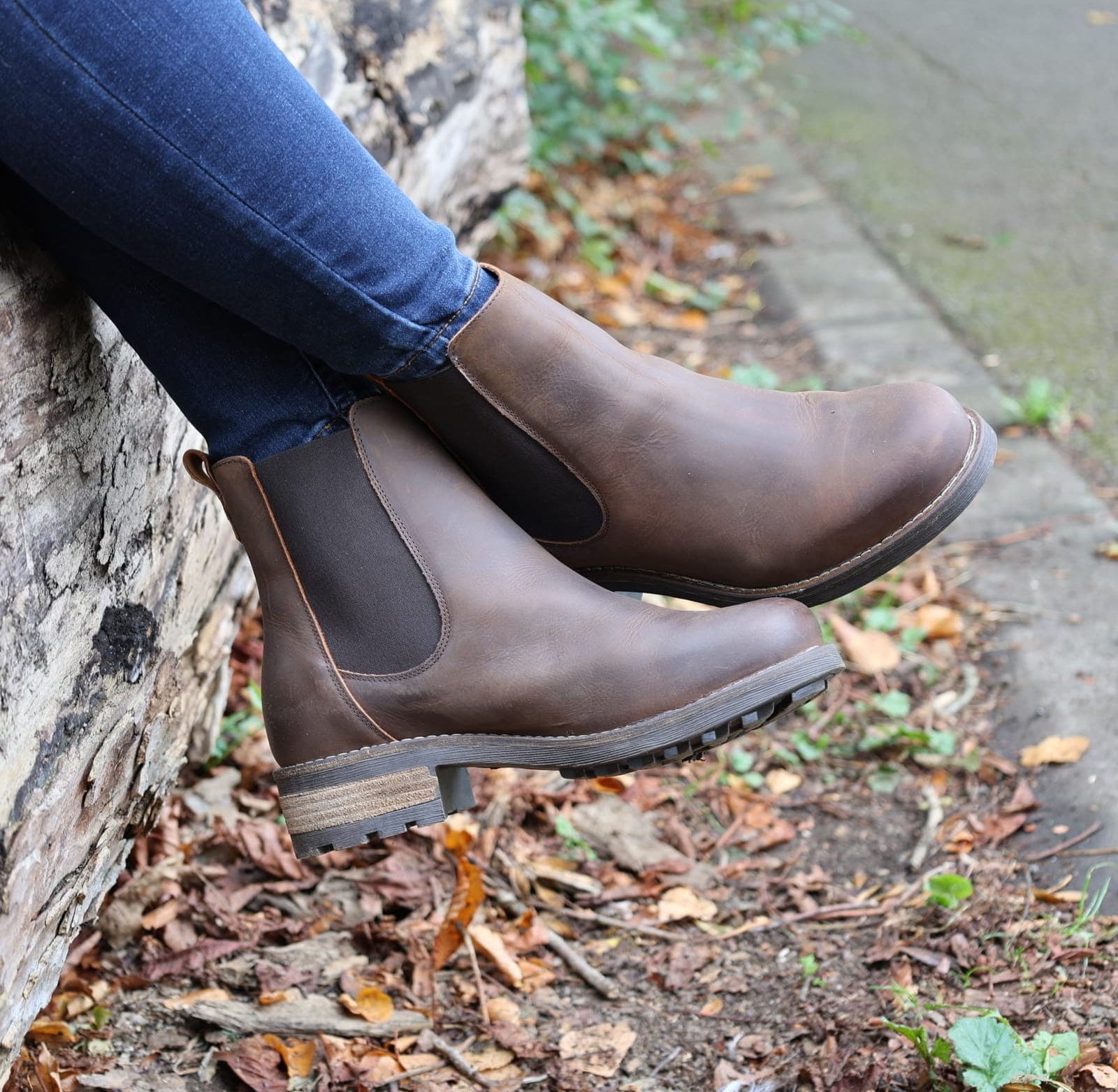 Dark brown Bridge Chelsea 2 boots worn outdoors sitting on a wall