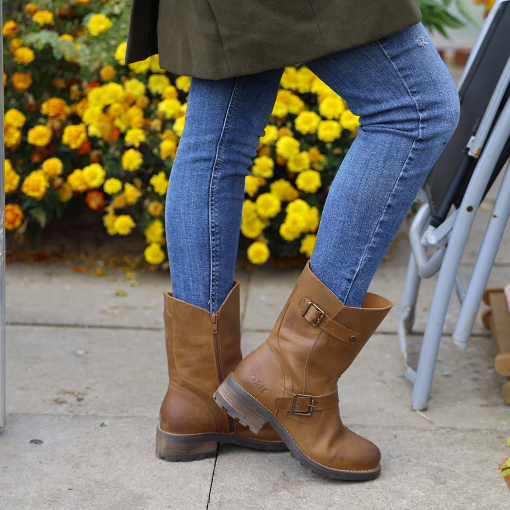 model standing outdoors wearing crest demi 2 boots in tan cognac with blue jeans
