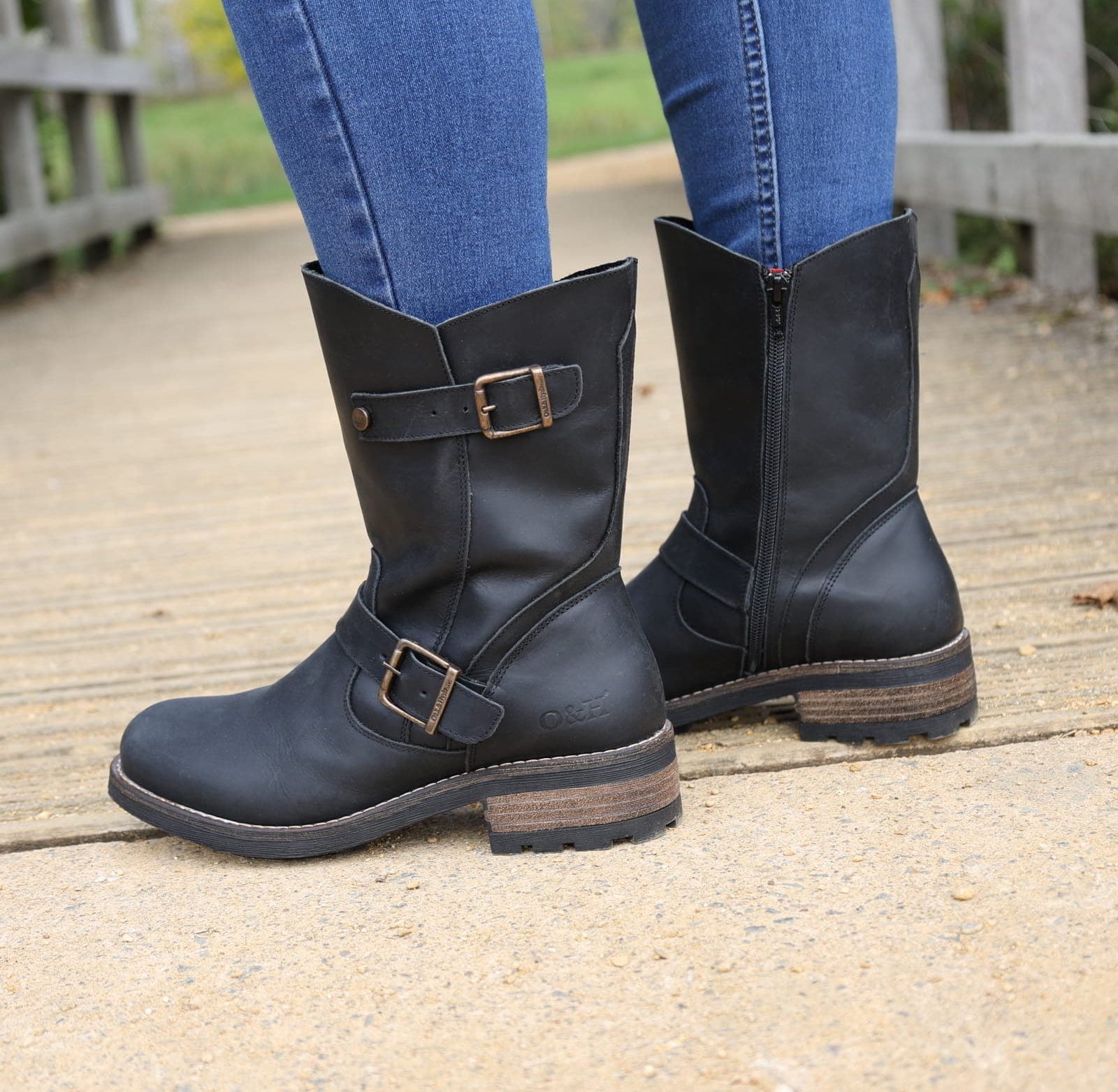 Black Crest Demi 2 ankle boots worn outdoors standing on a wooden walkway