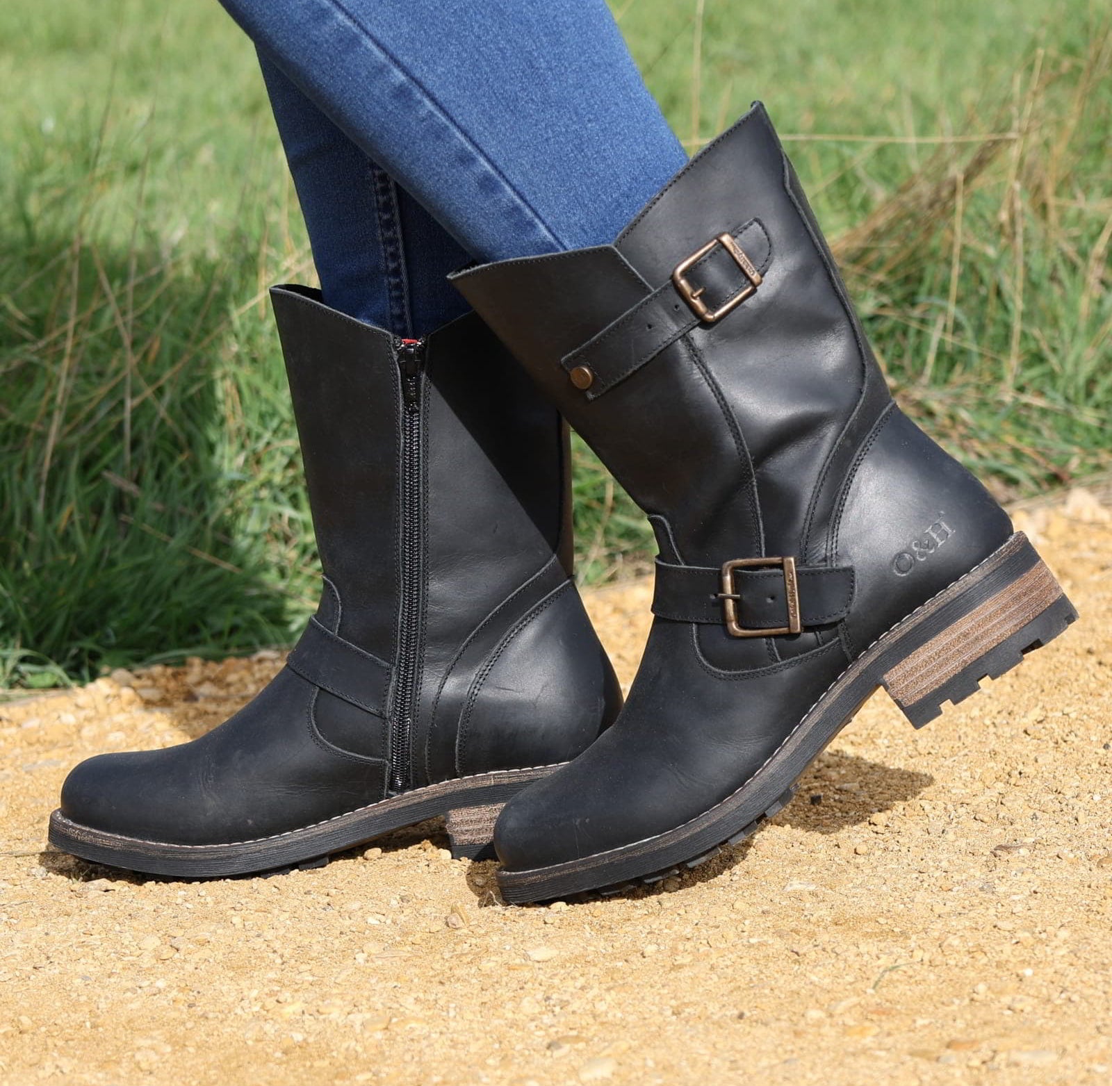 Black Crest Demi 2 ankle boots worn outdoors stepping on sandy ground