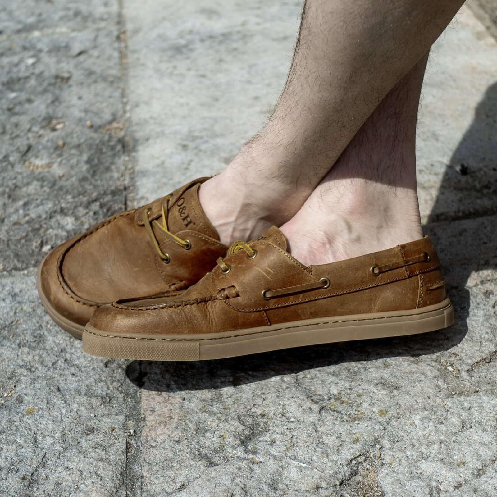 model sitting wearing cypress barefoot shoes in tan outdoors