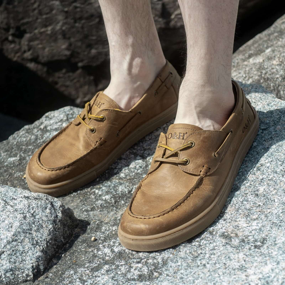model standing on rocks wearing cypress barefoot shoes in tan