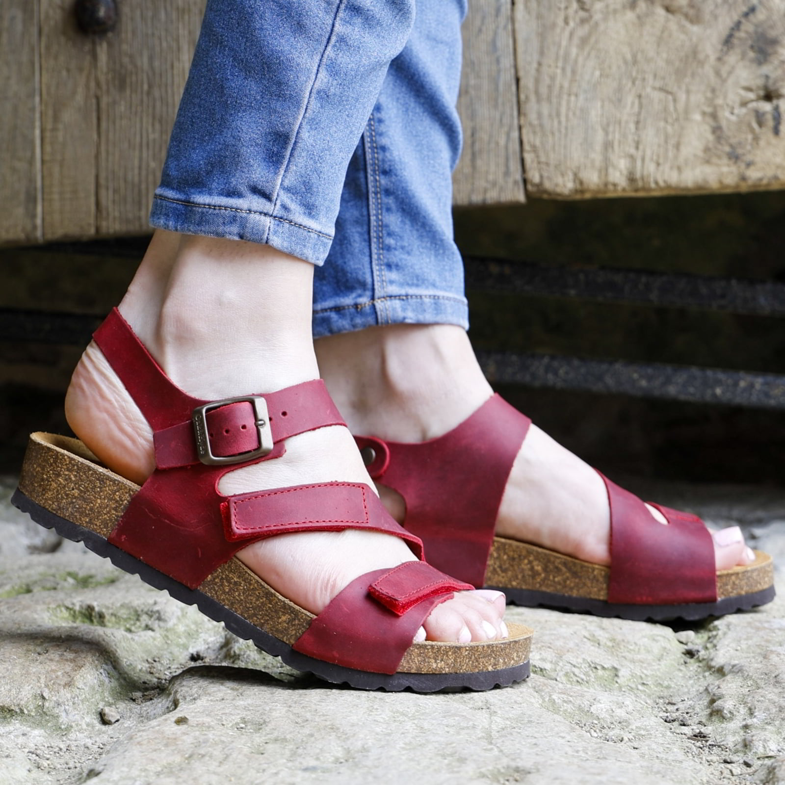 red oak & hyde daisy sandals worn with rolled jeans outdoors on stone ground