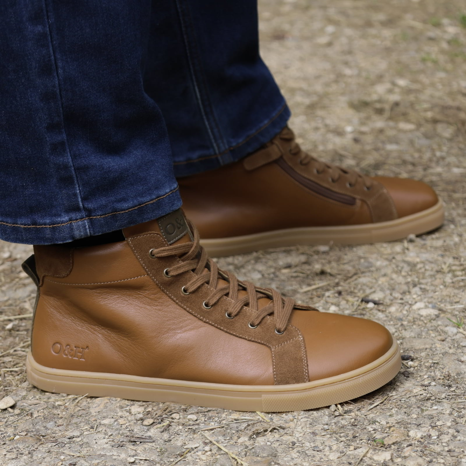 model standing outdoors wearing mens elm barefoot ankle boots with blue jeans