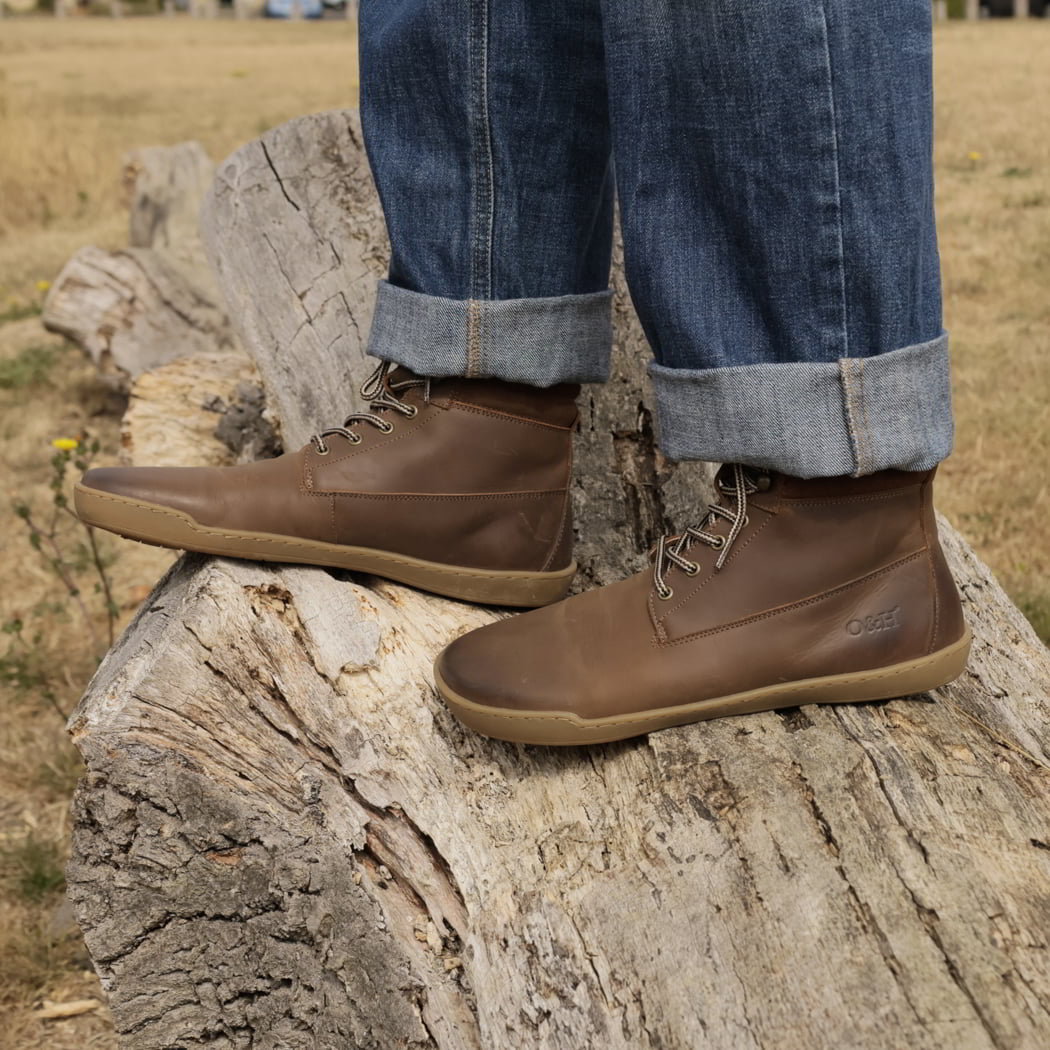 model standing on tree stump in hawthorn barefoot boots in dark brown