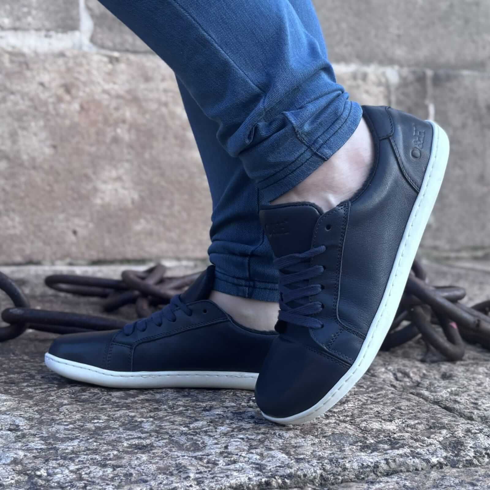 model wearing blue barefoot trainers with light blue jeans on pavement