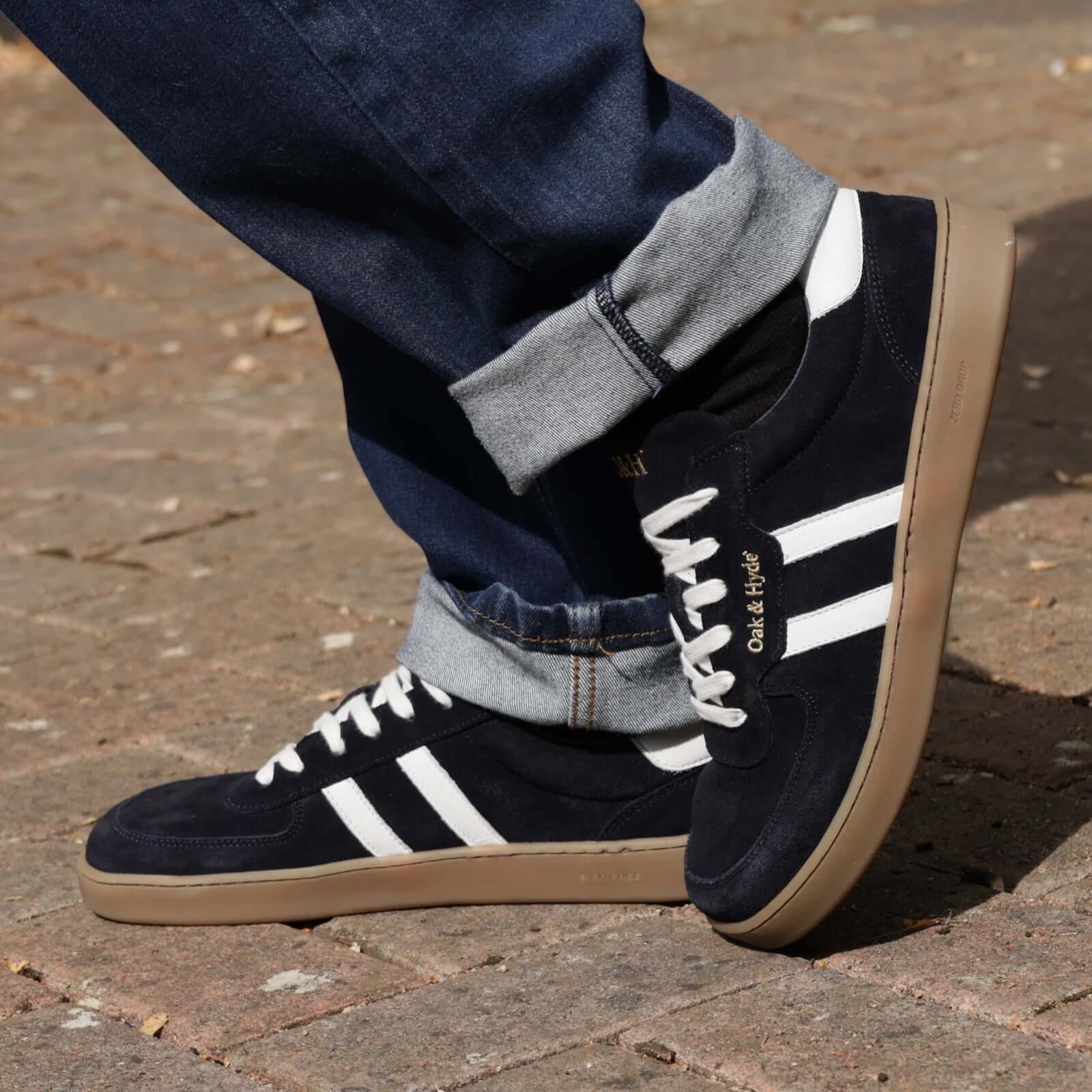 model standing outdoors on pavement in mens larch barefoot trainers in navy