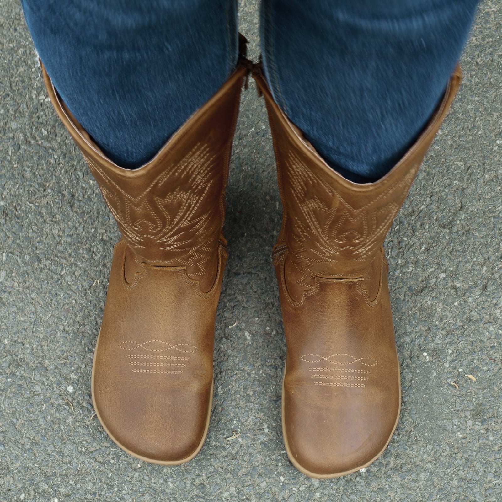 modeal wearing cognac barefoot cowboy boots showing a top down view of the toe shape