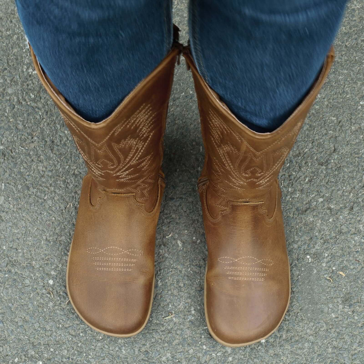 modeal wearing cognac barefoot cowboy boots showing a top down view of the toe shape