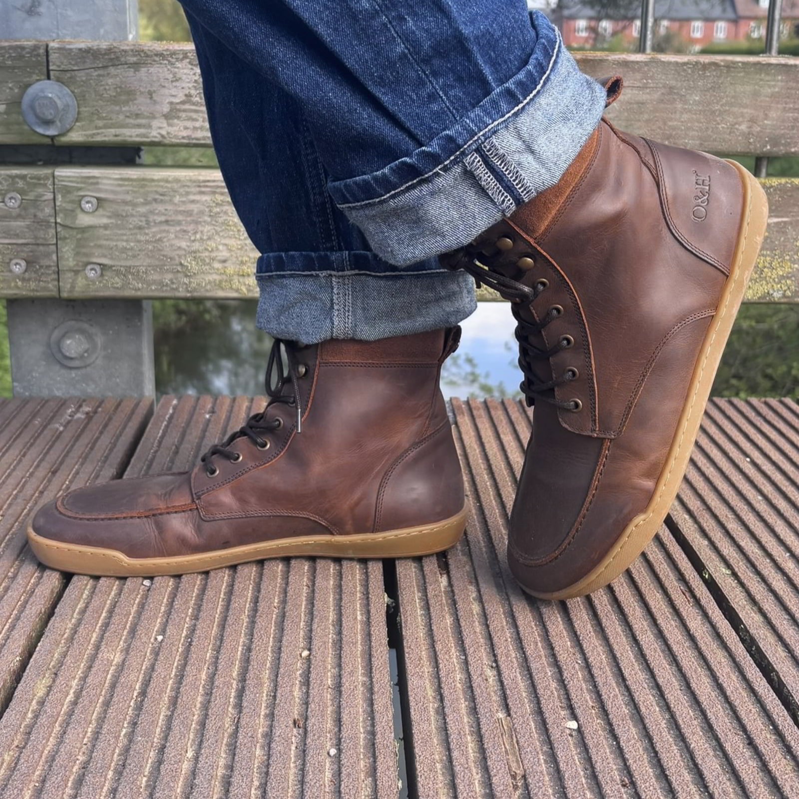 model wearing redwood barefoot ankle boots in dark brown stood on bridge