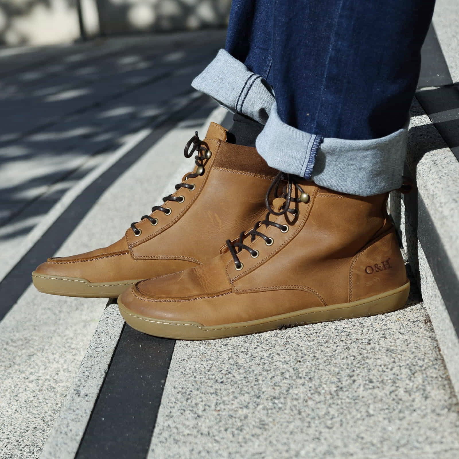 model sitting on step wearing redwood boots in tan with blue jeans