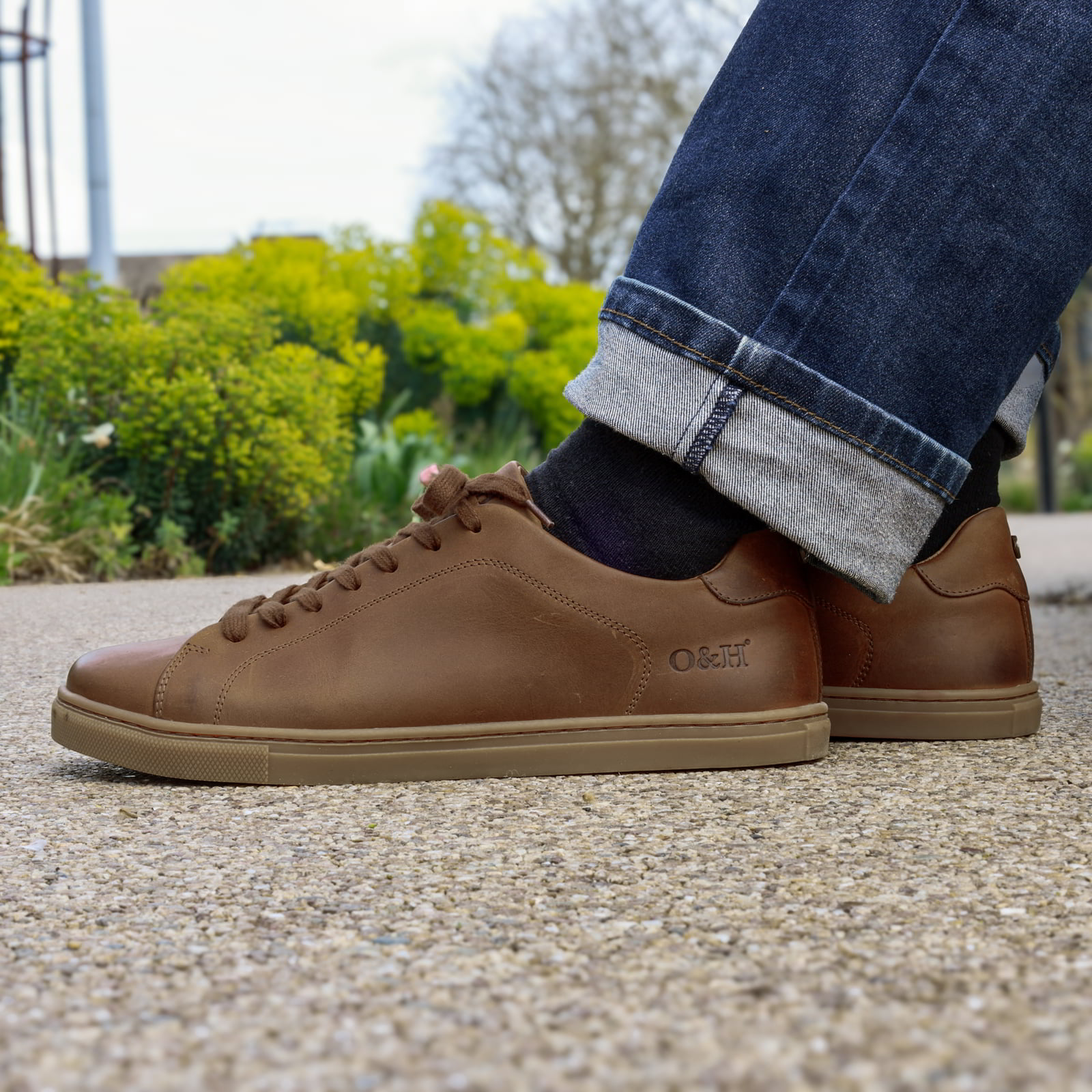 model sitting on bench wearing rowan cognac barefoot shoes with blue jeans