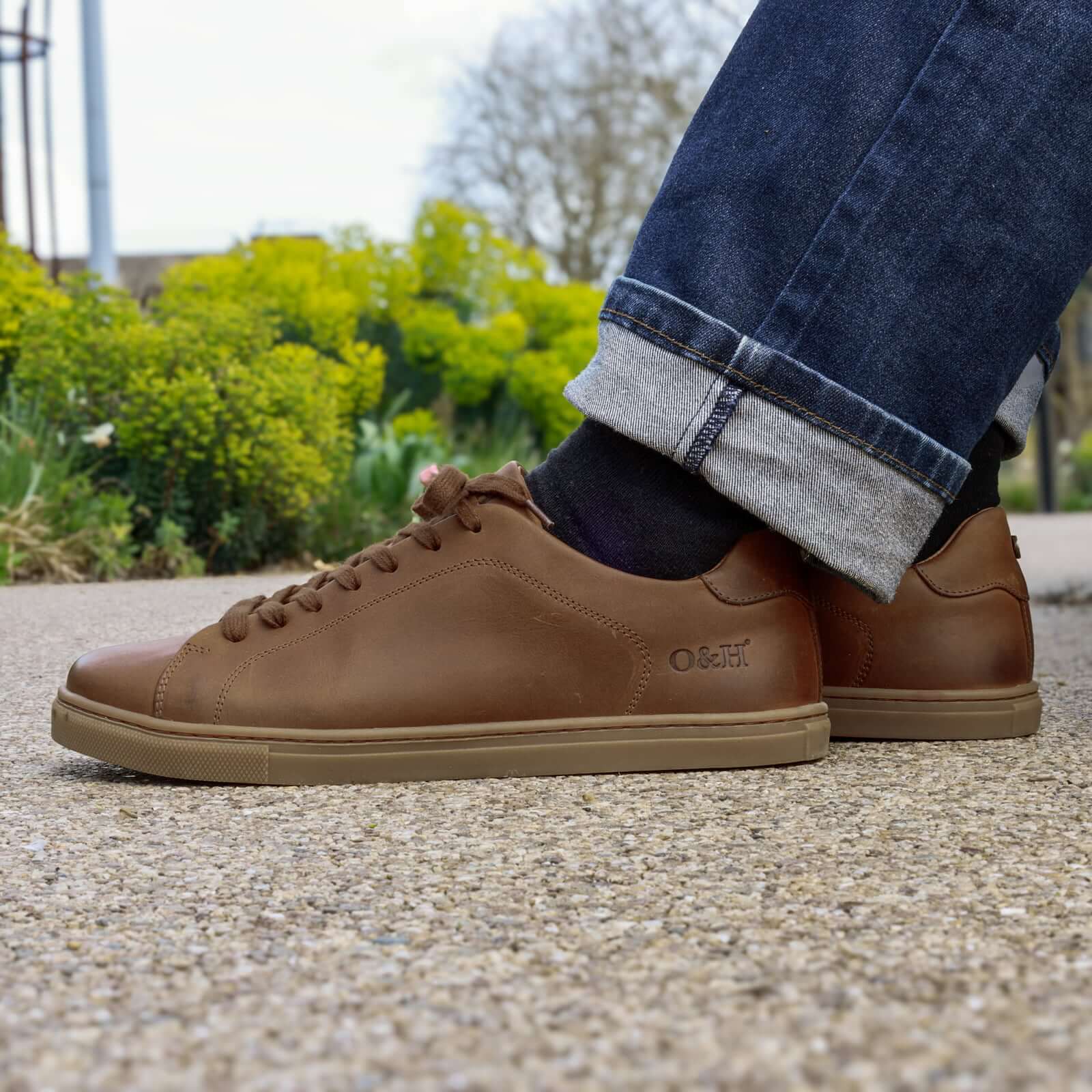 model sitting on bench wearing rowan cognac barefoot shoes with blue jeans