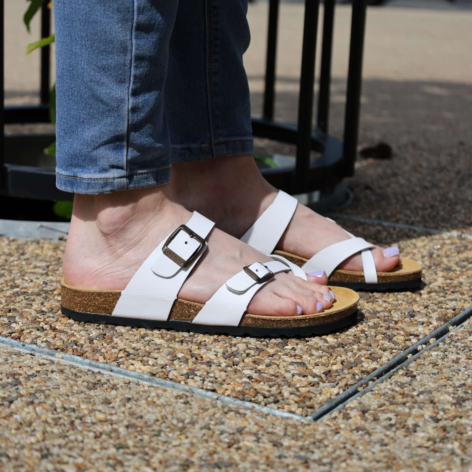 model wearing savannah 2 sandals white with denim jeans stood on a pavement