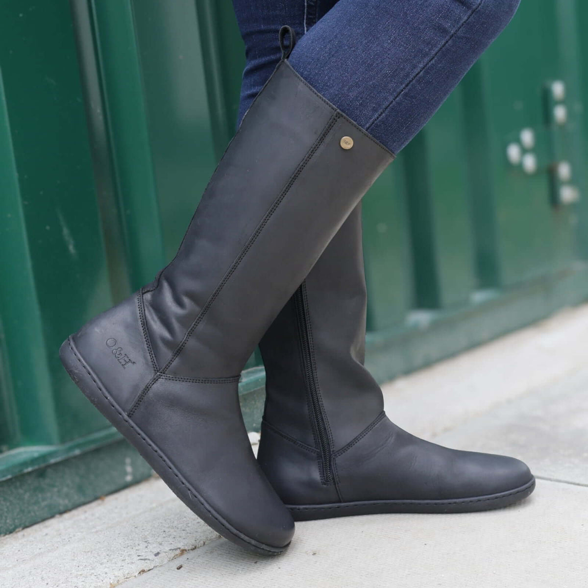 model wearing sycamore 2 barefoot boots with blue jeans standing outdoors