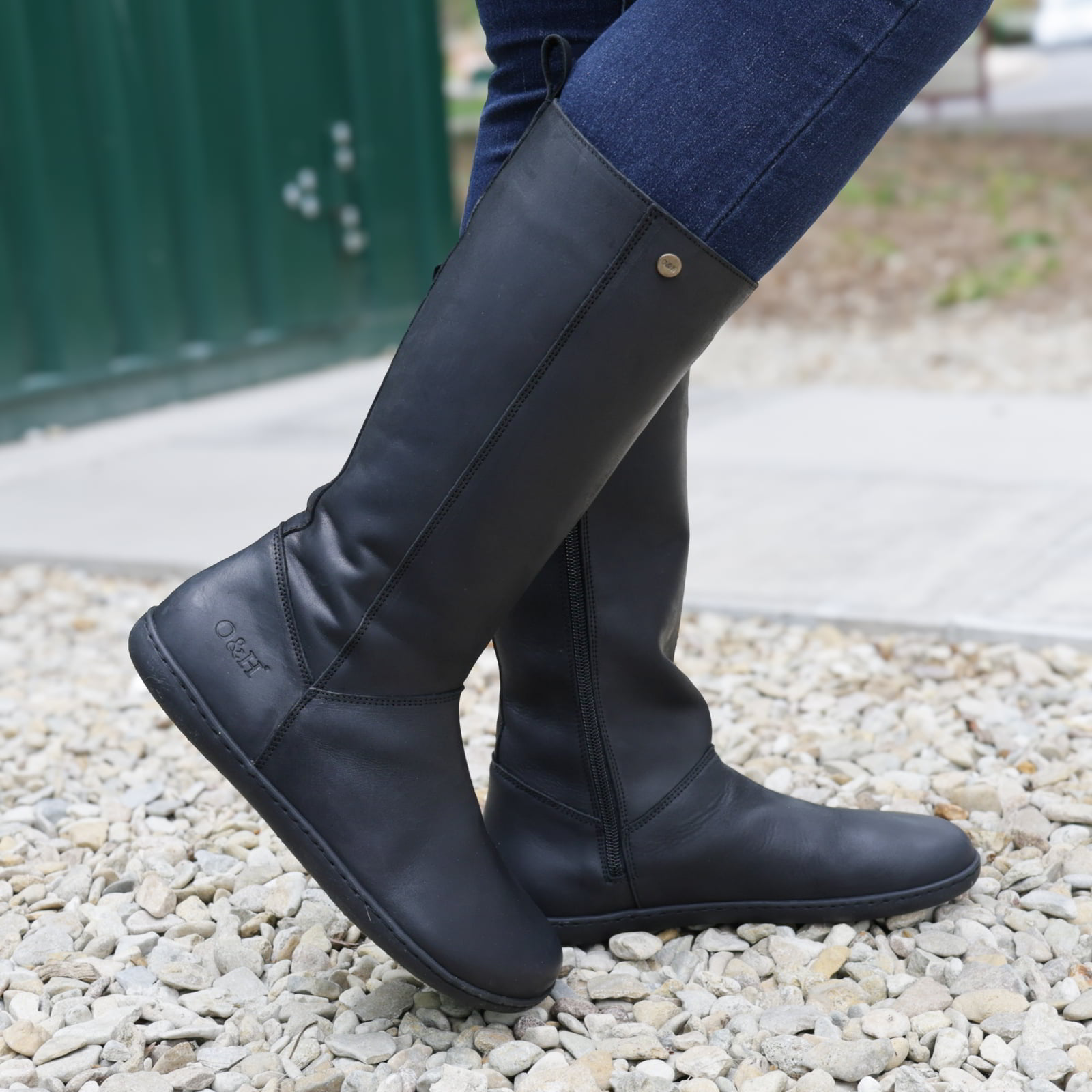 model standing outdoors waring sycamore barefoot boots in black with blue jeans
