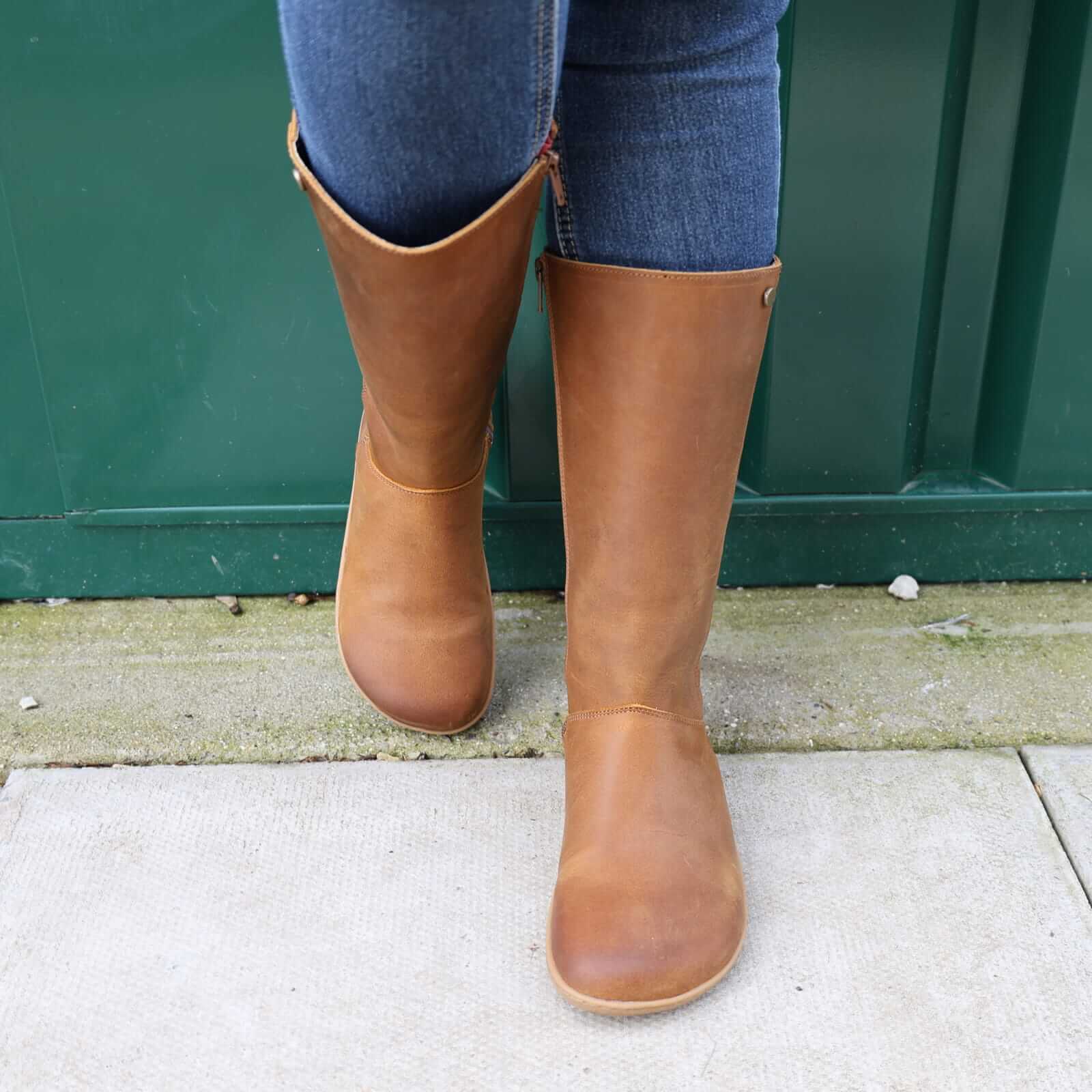 model wearing tan brown barefoot boots showing toe shape on concrete floor