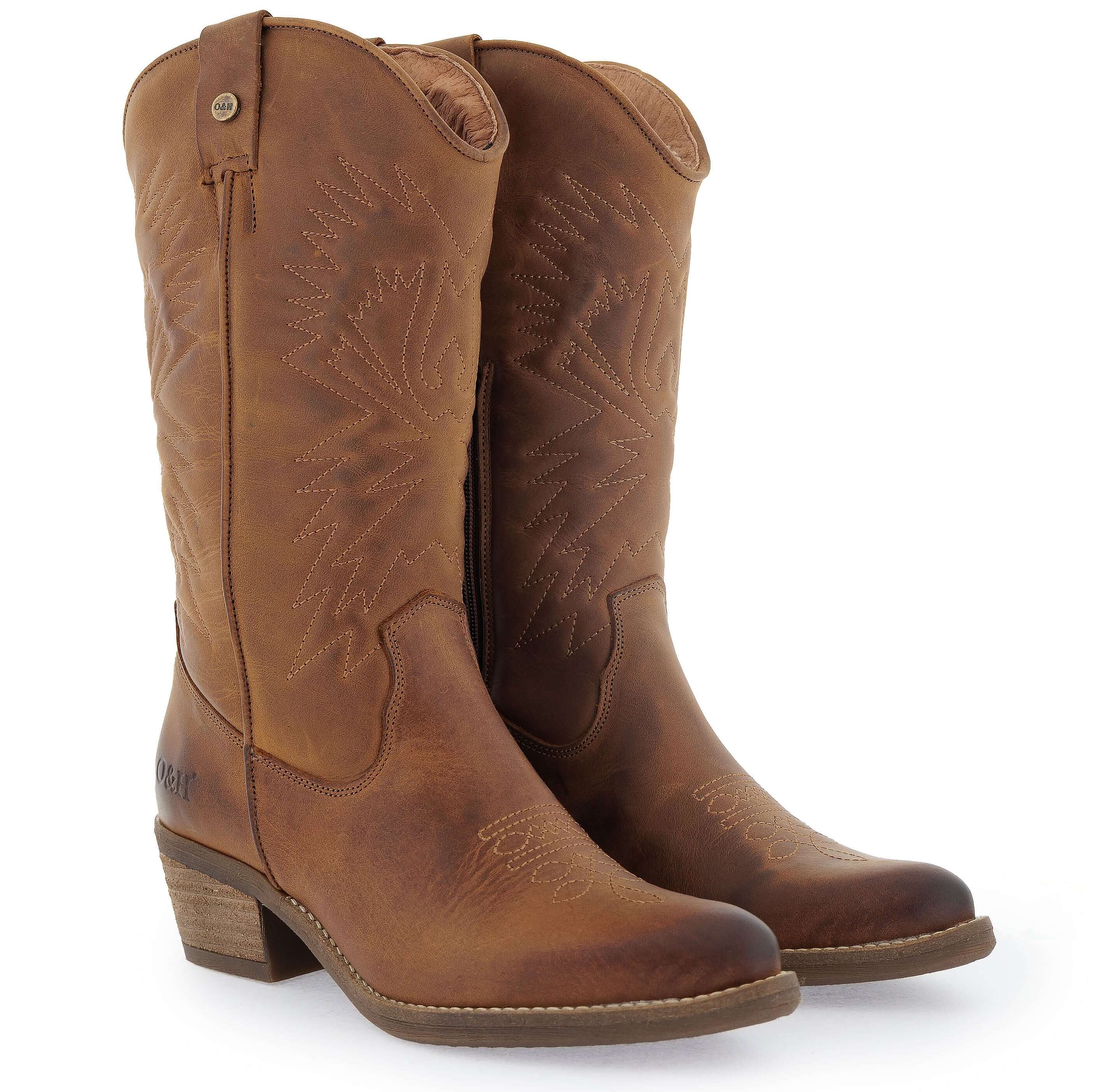 A pair of tan cognac colored, pointed-toe western cowboy boots with stitch detailing and a low heel.