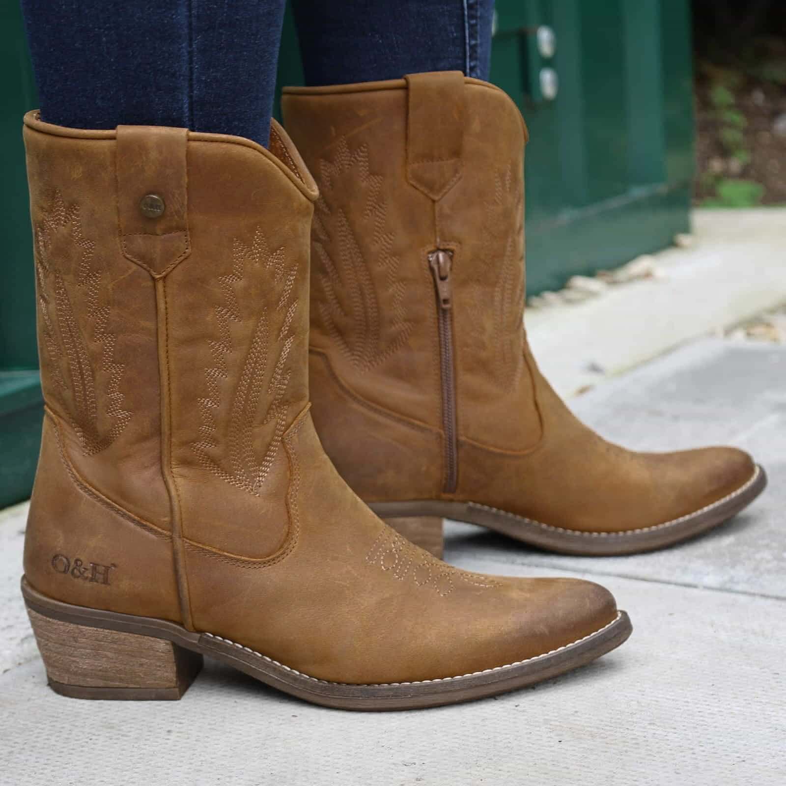 model wearing texan lo cowboy boots in tan with dark blue jeans on pavement