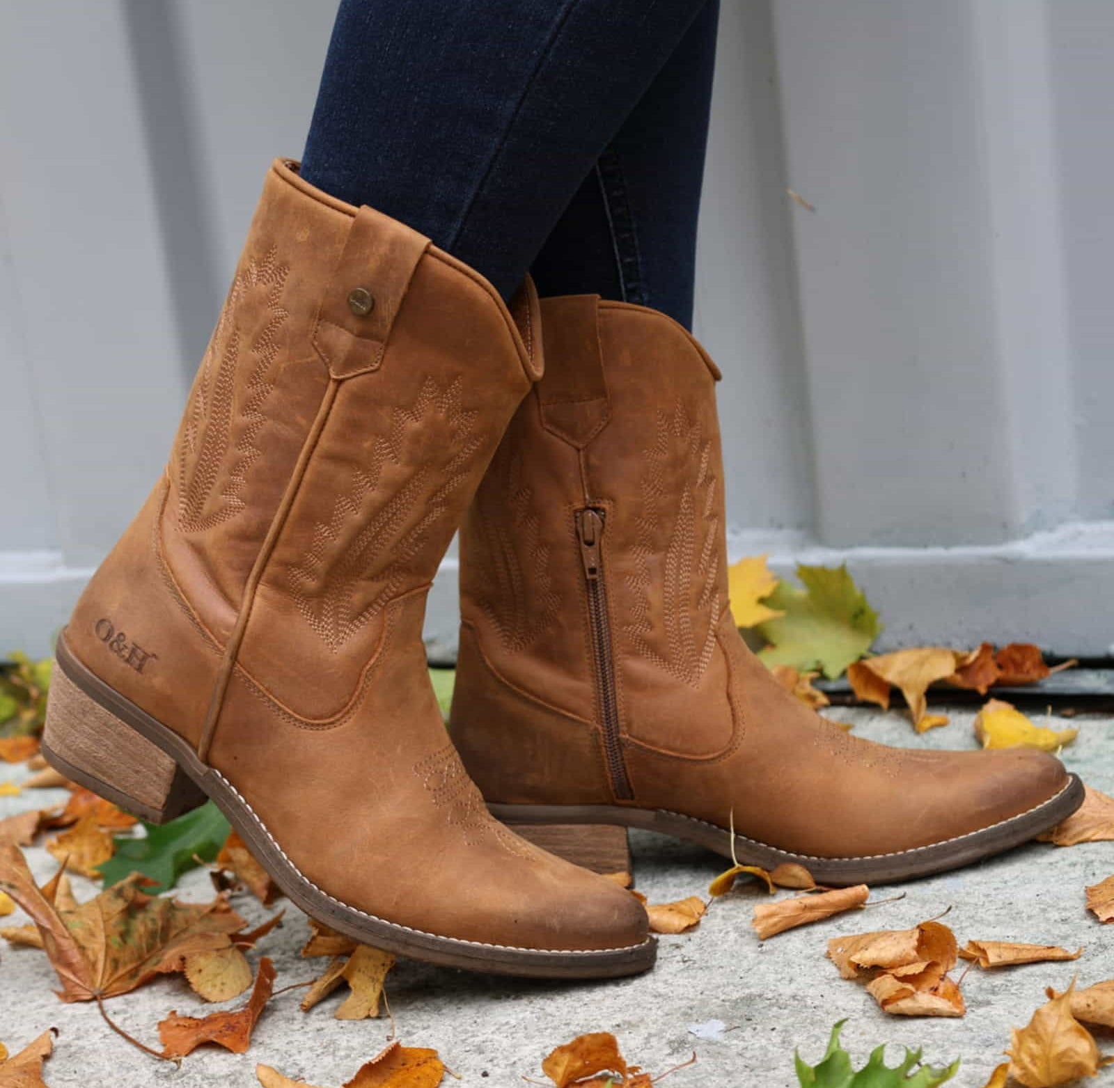model standing on concrete in leaves wearing texan lo cowboy boots with jeans