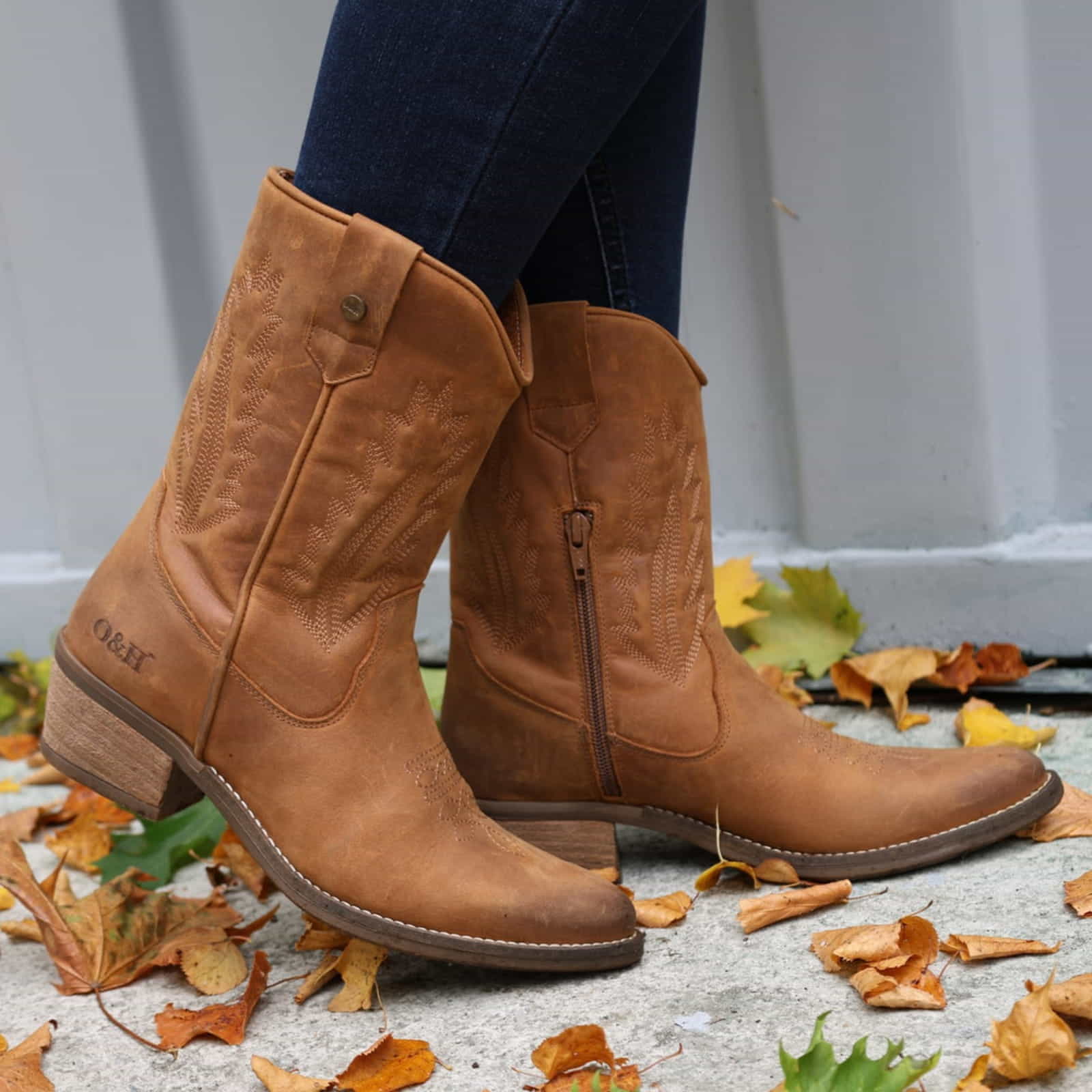 model standing on concrete in leaves wearing texan lo cowboy boots with jeans