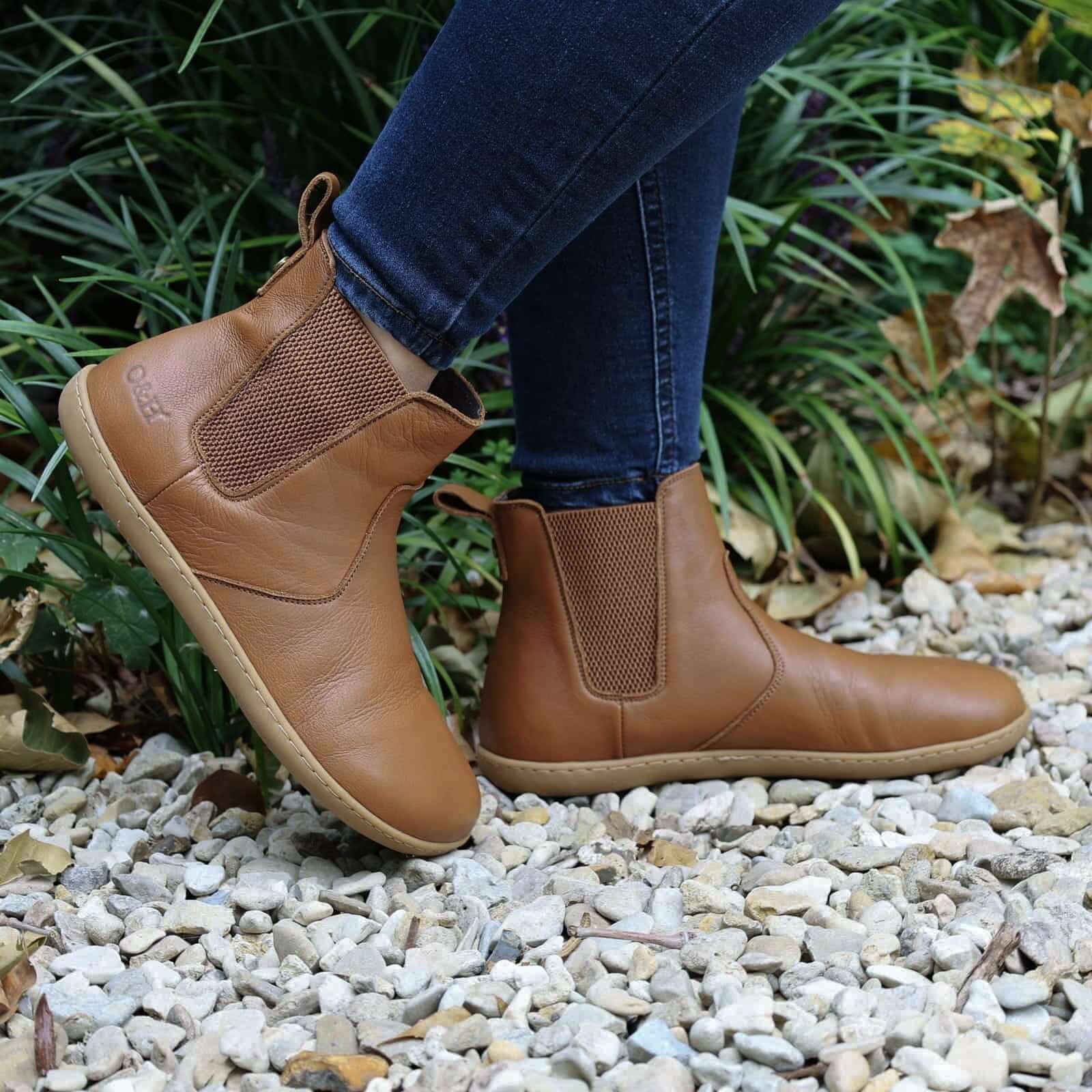 model wearing tan barefoot chelsea boots in an outdoor setting