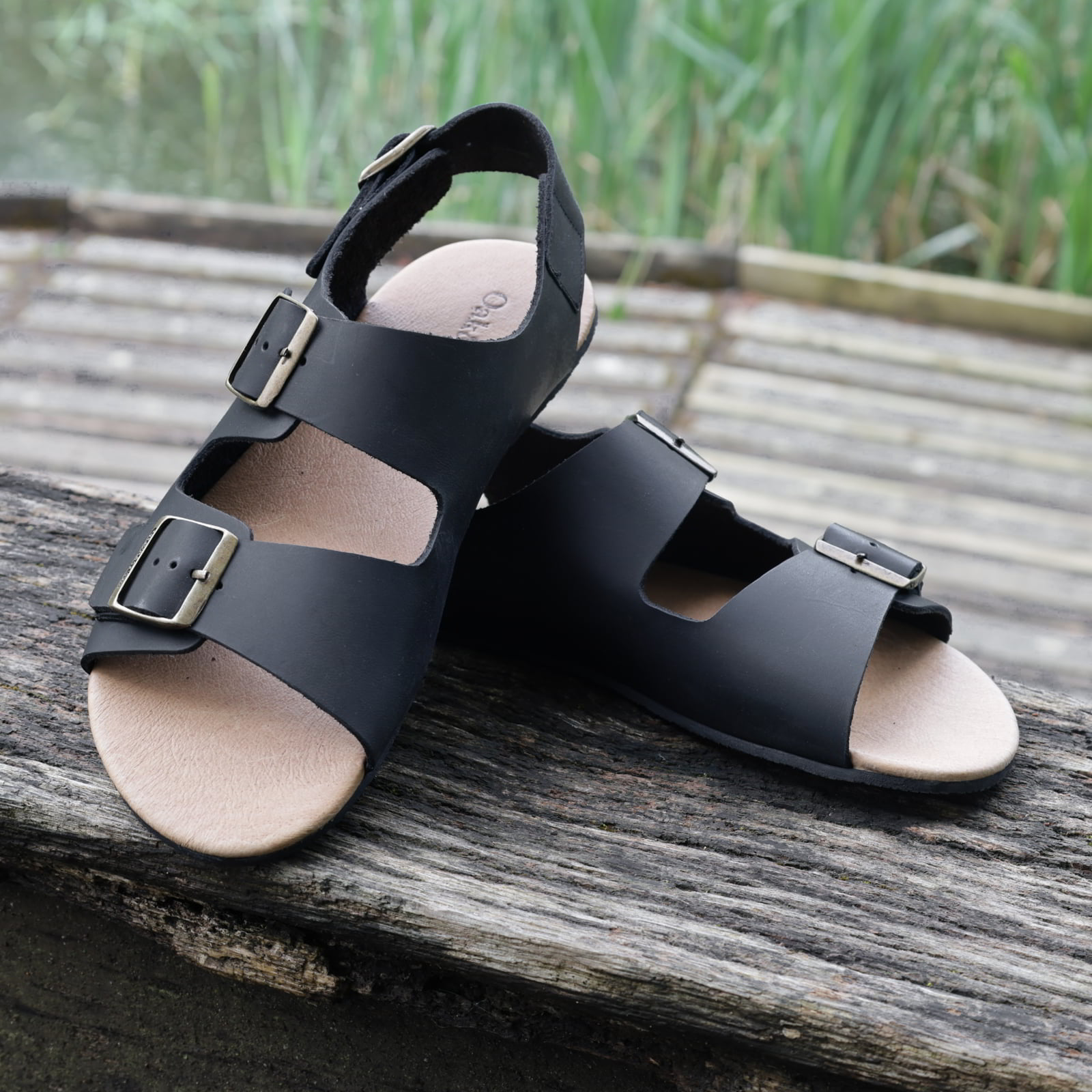 pair of wisteria barefoot sandals in black outside showing the toe shape of the sandals