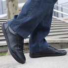 model standing in black barefoot trainers paired with casual dark jeans