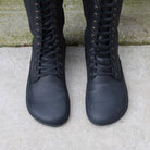 Birdseye view of model wearing black barefoot boots showing wide toe box