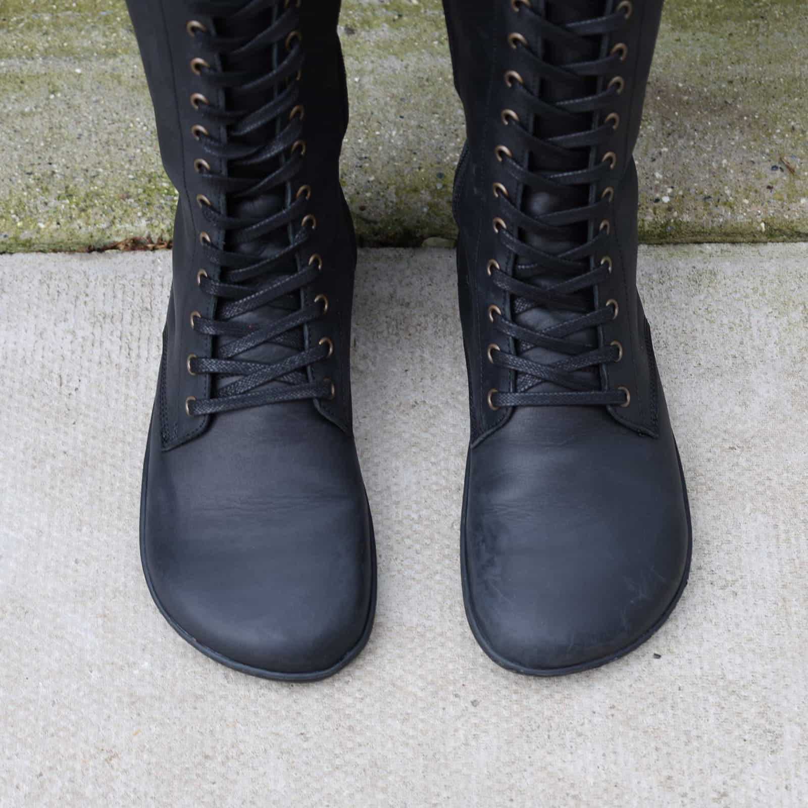 Birdseye view of model wearing black barefoot boots showing wide toe box