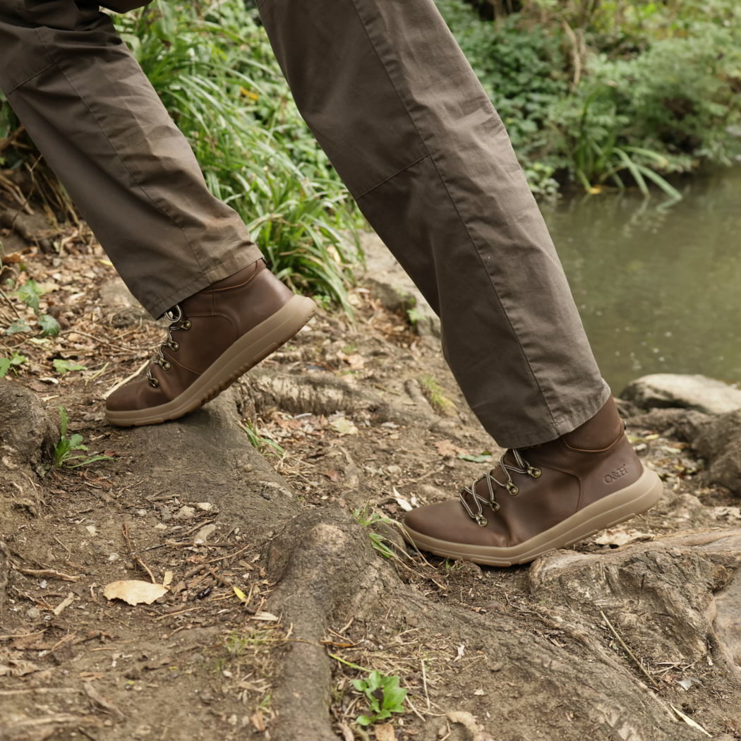 model walking in woodland wearing mens blackthorn barefoot walking boots in brown