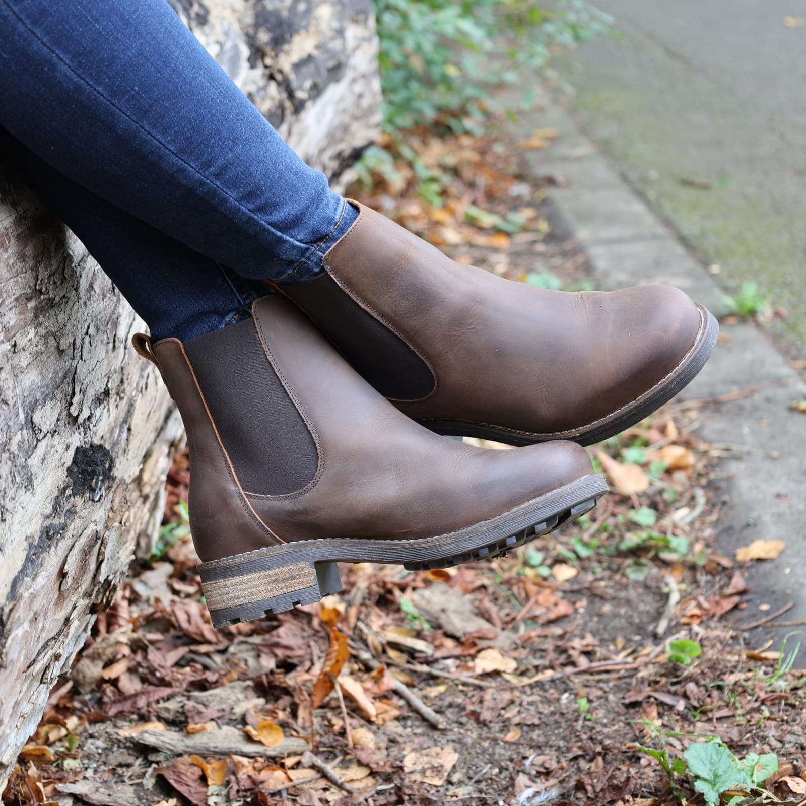 Dark brown Bridge Chelsea 2 boots worn outdoors sitting on a wall