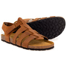 Pair of tan leather fisherman sandals, one showing the patterned black rubber sole and cork footbed