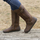 model standing outdoors wearing cedar barefoot boots in brown with blue jeans