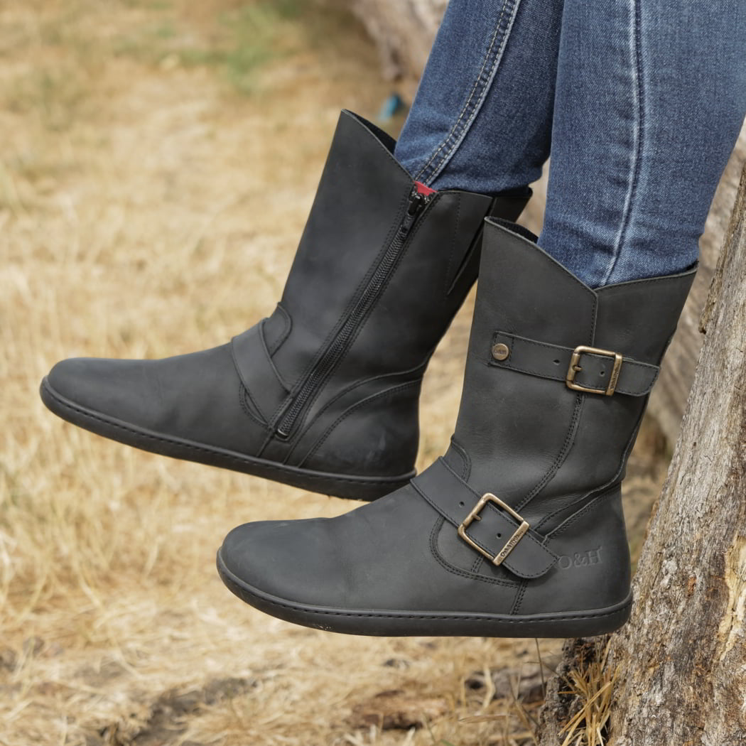 person sitting outdoors wearing cedar demi barefoot boots in black with blue jeans