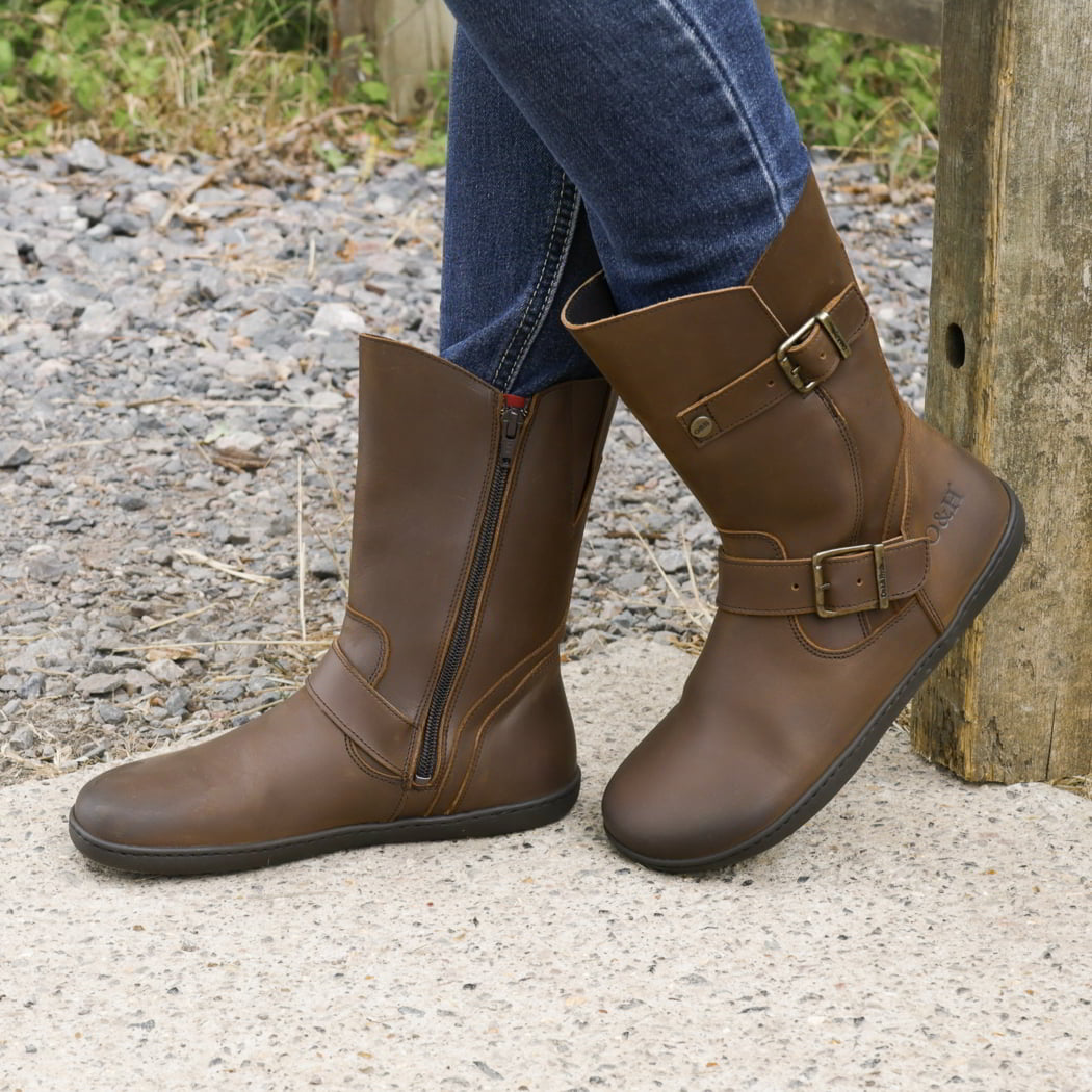 model standing outdoors wearing cedar demi barefoot boots in dark brown