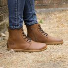 model wearing womens cherry cognac barefoot boots on grass floor