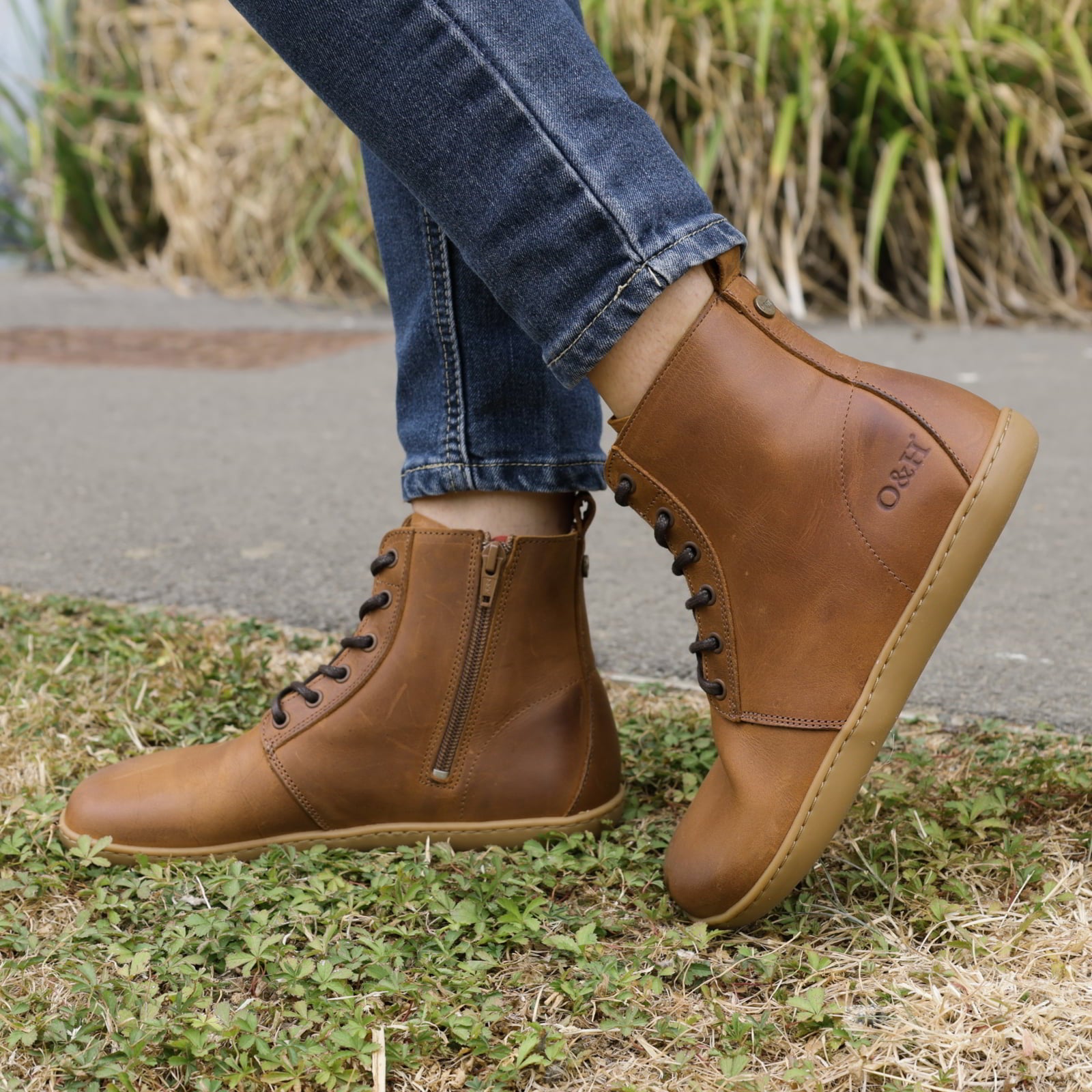 person wearing womens cherry barefoot ankle boots in cognac with blue jeans outdoors