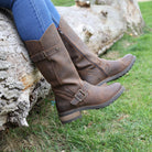 Dark brown Crest 2 tall boots worn outdoors with feet resting on stone