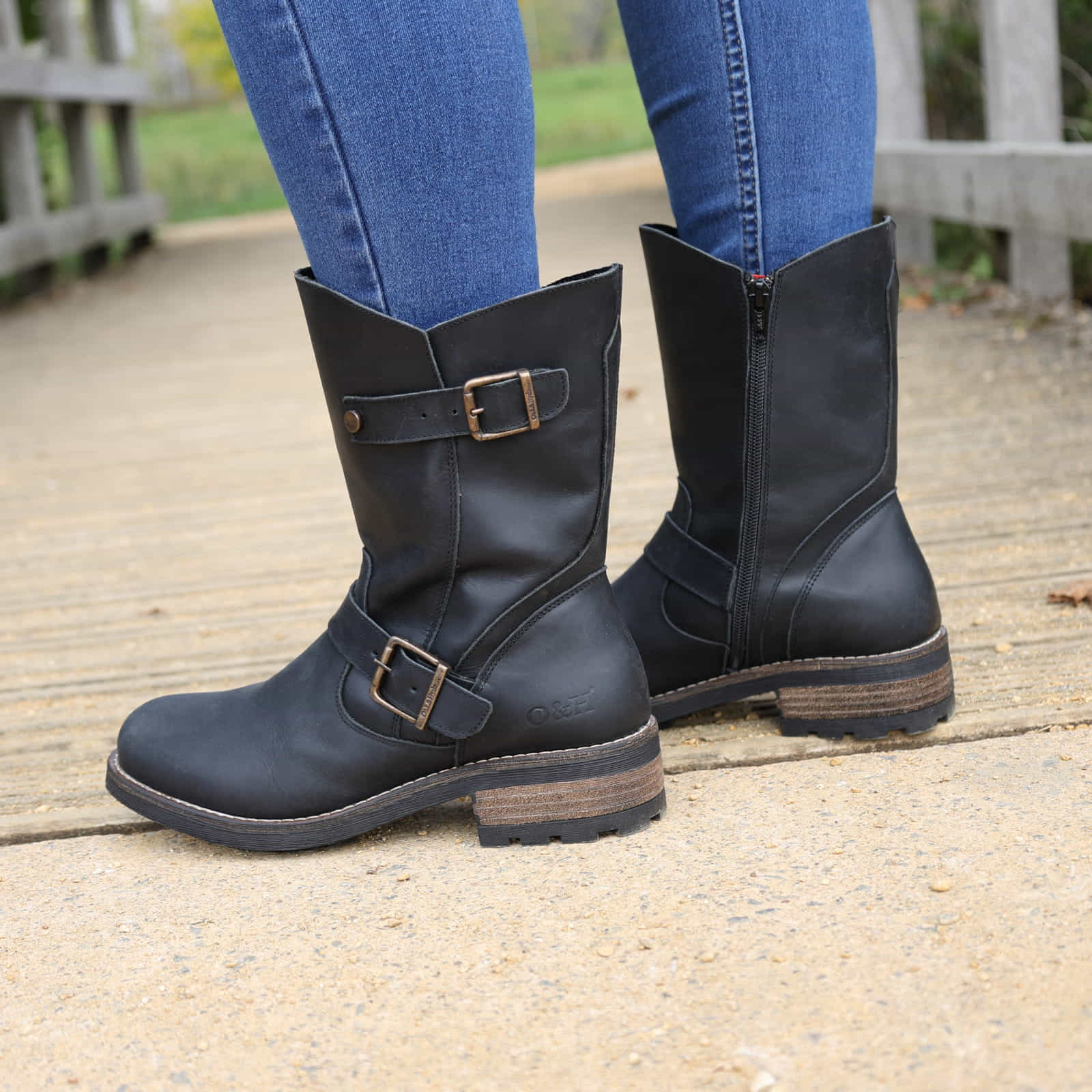 Black Crest Demi 2 ankle boots worn outdoors standing on a wooden walkway