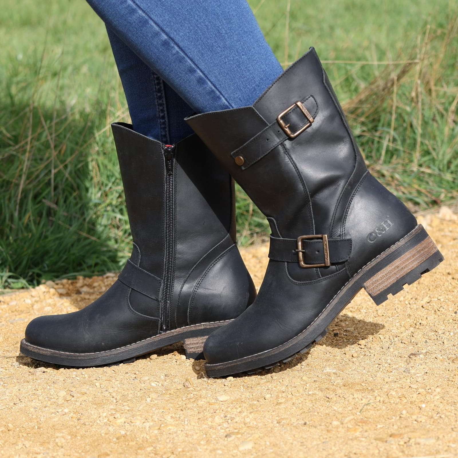 Black Crest Demi 2 ankle boots worn outdoors stepping on sandy ground