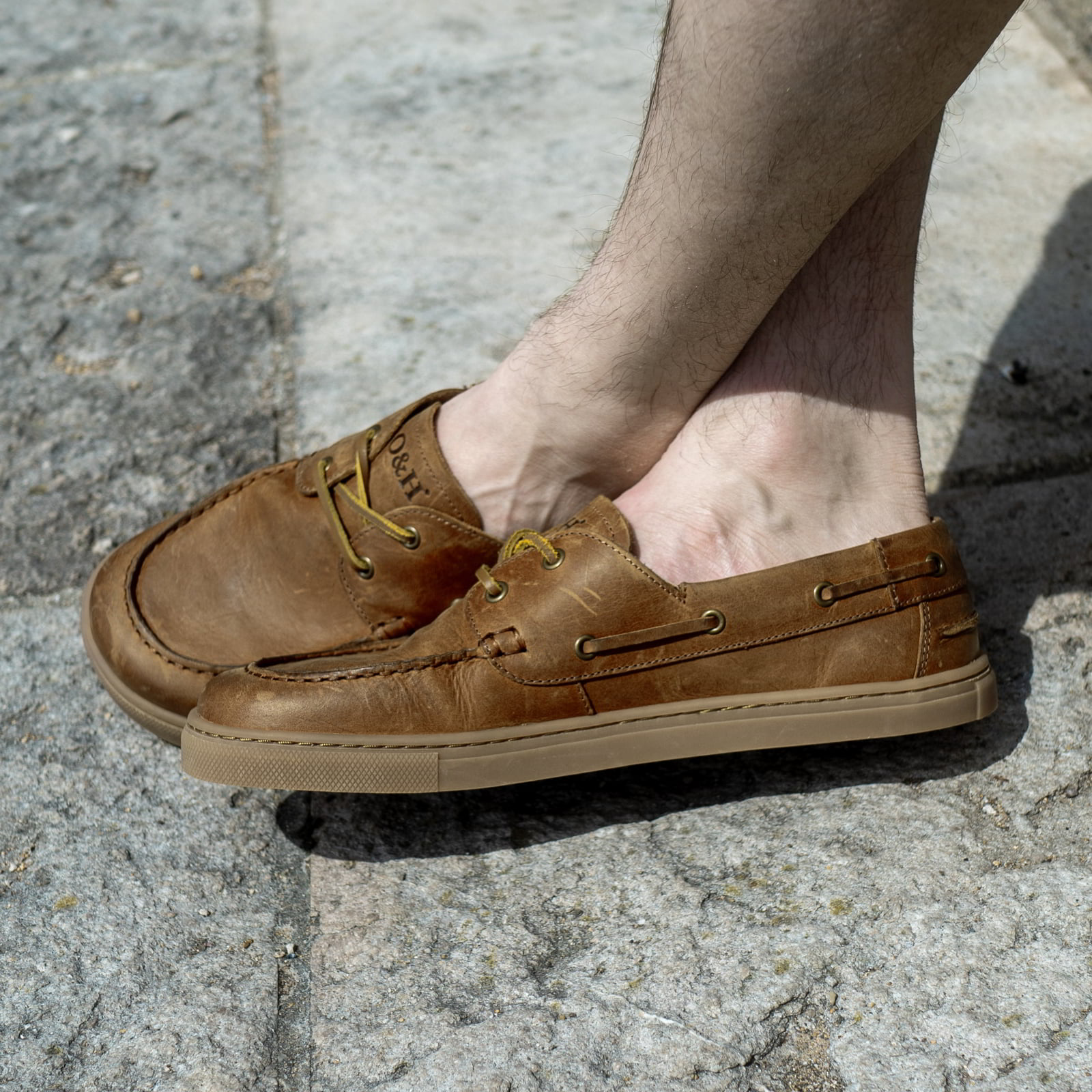 model sitting wearing cypress barefoot shoes in tan outdoors