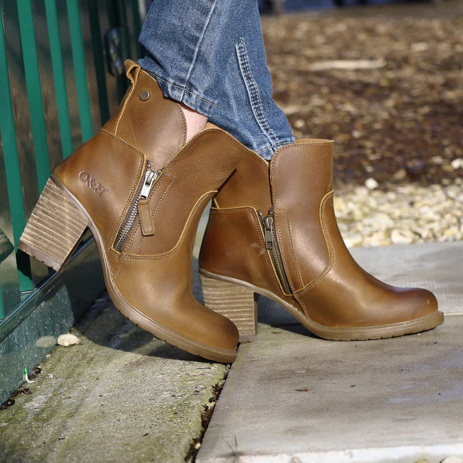 model leaning against metal container wearing Eastside 2 western boots with jeans