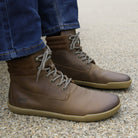 model sitting on bench wearing hawthorn mens barefoot boots in brown
