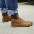 model wearing hawthorn barefoot boots with blue jeans on a pebbled path
