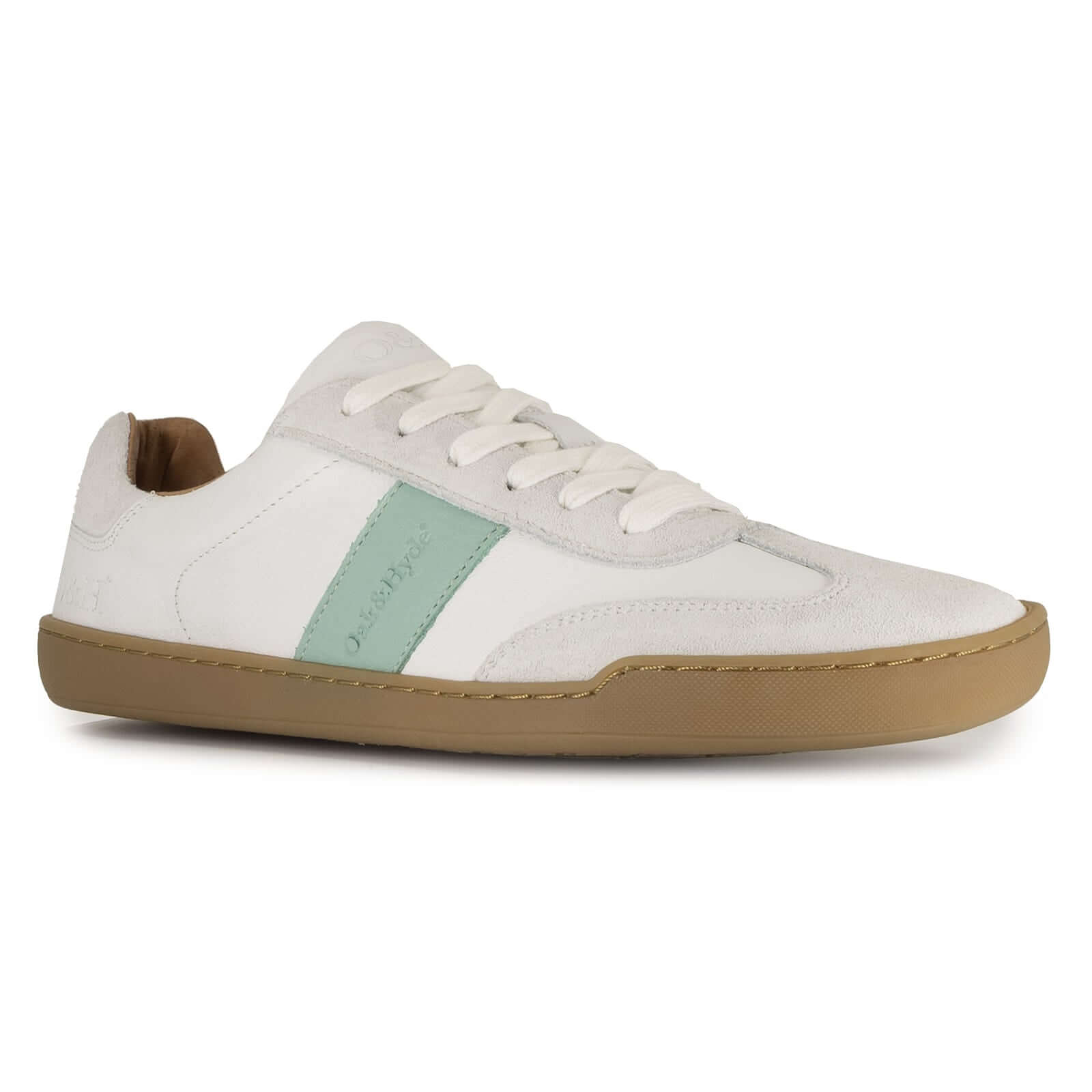 White barefoot trainer with gum sole and green accent on a white background
