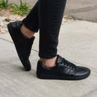 model wearing juniper all black barefoot trainers with dark jeans on a pavement