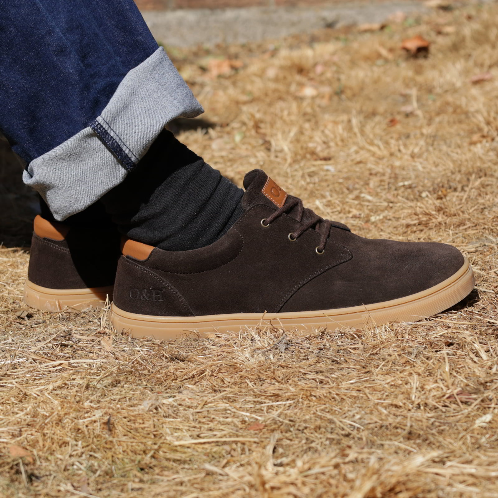 model sitting outdoors in the mens lawson barefoot shoes in dark brown with blue jeans